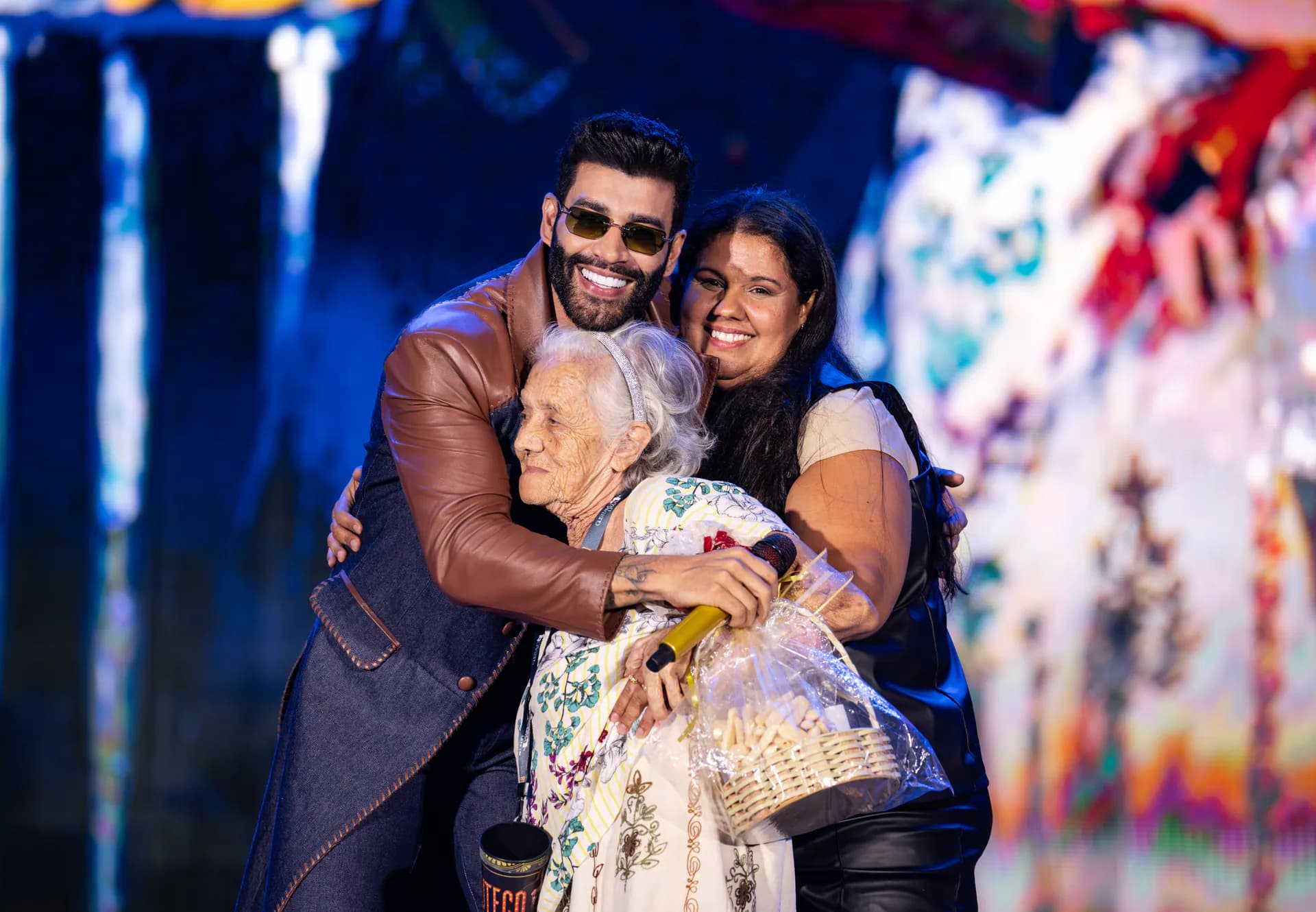 Gusttavo Lima abraça uma fã no palco
